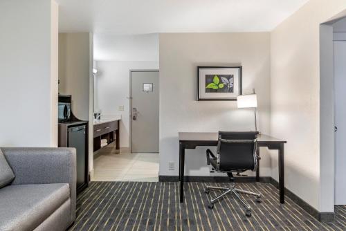 a hotel room with a desk and a chair at Comfort Inn & Suites Tigard near Washington Square in Tigard