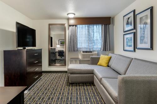 a living room with a couch and a television at Comfort Inn & Suites Tigard near Washington Square in Tigard