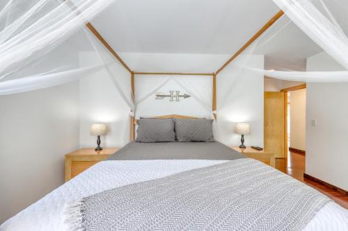 a bedroom with a white bed with two lamps at Contemporary Maine Retreat in Bethel