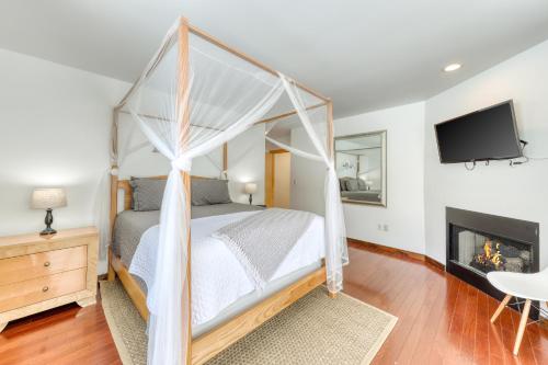 a bedroom with a canopy bed and a fireplace at Contemporary Maine Retreat in Bethel