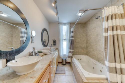 a bathroom with a large mirror and a tub and sink at Contemporary Maine Retreat in Bethel