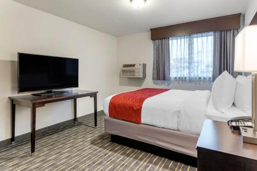 a hotel room with a bed and a flat screen tv at Comfort Inn & Suites Tigard near Washington Square in Tigard