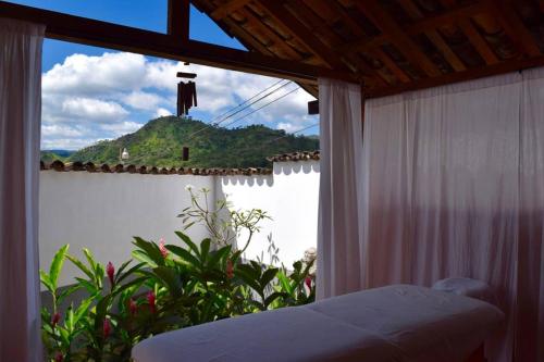 a bedroom with a view of a mountain from a window at La Casa de Dona Irma Townhouse in Copan Ruinas