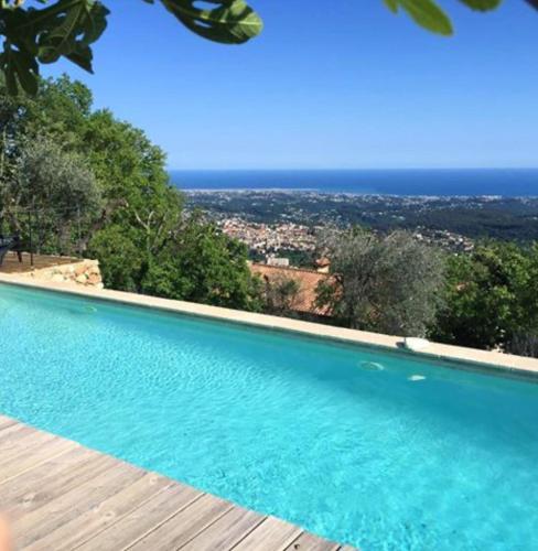 a swimming pool with a view of the ocean at Les Mas d'Azur Appartement in Vence