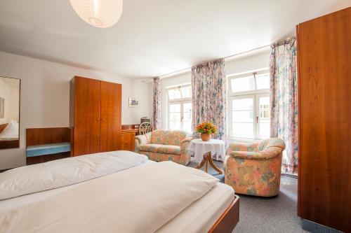 um quarto de hotel com uma cama e duas cadeiras em Ferienwohnungen zum Nachtwächter em Meersburg