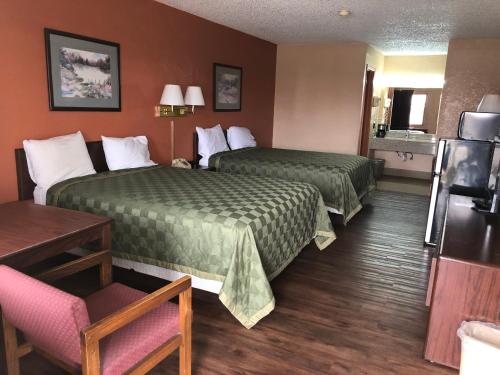 ein Hotelzimmer mit 2 Betten und einem Stuhl in der Unterkunft Lone Star Inn in Cisco