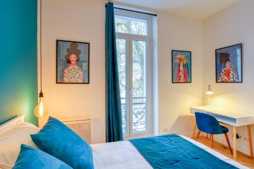 a bedroom with a bed and a desk and a window at Le Franklin Roosevelt in Marseille