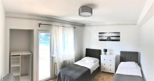- une chambre avec 2 lits et une fenêtre dans l'établissement Apartments & Rooms Formenti, à Skradin