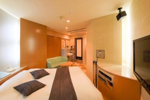 a bedroom with a large bed and a television at Osaka - Hotel / Vacation STAY 70140 in Osaka