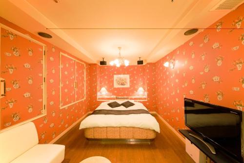 a bedroom with orange wallpaper and a bed in it at Osaka - Hotel / Vacation STAY 70127 in Osaka