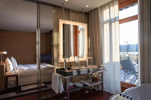 a bathroom with a bed and a sink and a mirror at La Réserve Eden au Lac Zurich in Zürich