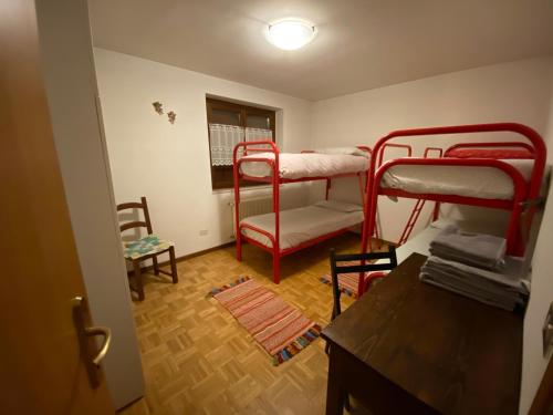 a room with two bunk beds and a table at Appartamento di Viola & Elia in Predazzo