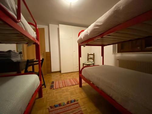 a bedroom with two bunk beds and a chair at Appartamento di Viola & Elia in Predazzo