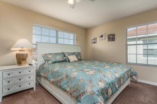 Schlafzimmer mit einem Bett, einer Lampe und Fenstern in der Unterkunft Paradise Palms-RU580 in Kissimmee