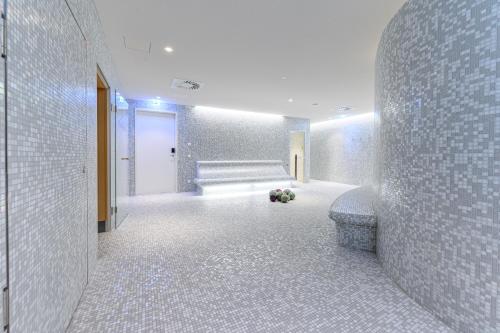 a bathroom with ailed hallway with a bench and flowers at Hotel Caroline in Vienna