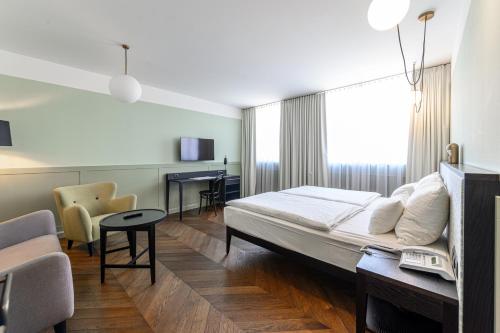 ein Hotelzimmer mit einem Bett, einem Tisch und Stühlen in der Unterkunft Hotel Caroline in Wien