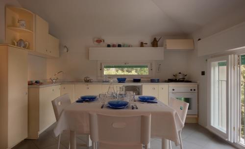 マリーナ・ディ・ピエトラサンタにあるMaestrale 2のテーブルと椅子、テーブルクロス付きのキッチンが備わります。