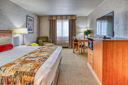 ein Hotelzimmer mit einem Bett und einem Flachbild-TV in der Unterkunft Rory & Ryan Inn in Burns