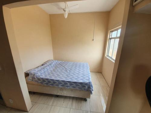 a small bedroom with a bed in the corner at Santorini Flats in Arraial do Cabo
