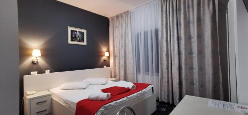 Un dormitorio con una cama con toallas rojas y blancas. en Hotel Cristian en Afumaţi