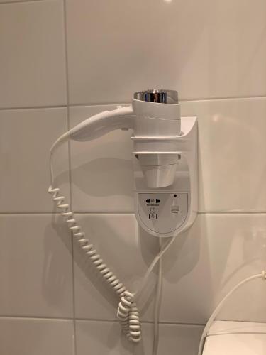 a phone on a wall next to a toilet at Hotel Grand Canal in Delft