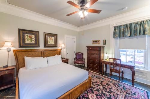 a bedroom with a bed and a desk and a window at Chipman Hill Suites - Union Street in Saint John