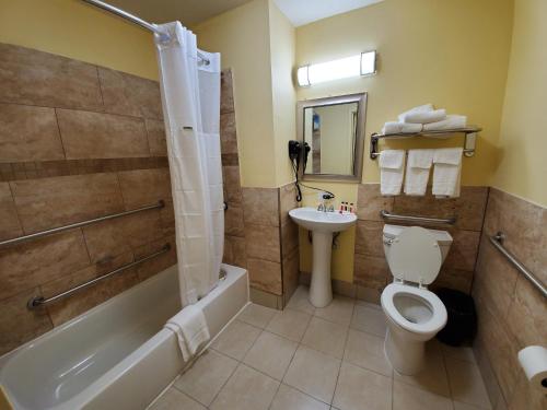 y baño con bañera, aseo y lavamanos. en Days Inn by Wyndham Atlanta/Southlake/Morrow en Morrow