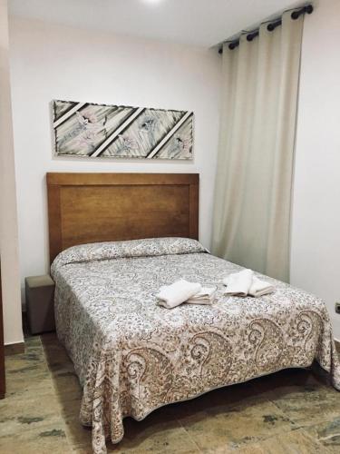 una camera da letto con un letto su cui sono appoggiati due asciugamani di Avenida Reyes Católicos a Chiclana de la Frontera