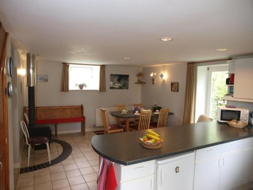 a kitchen and living room with a table and a dining room at Ty r Pwmp in Haverfordwest