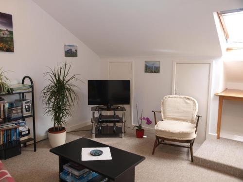 a living room with a chair and a television at Ty r Pwmp in Haverfordwest