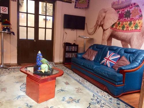 salon z niebieską kanapą i słoniem na ścianie w obiekcie Huasi Lodge w mieście Quito