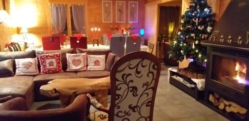 a living room with a christmas tree and a couch at Chalet TERRA LOUP in Le Dévoluy