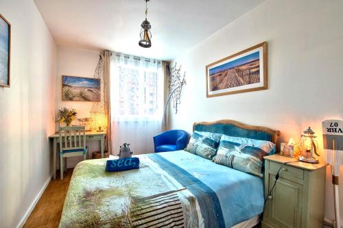 a bedroom with a bed with a blue bedspread at NATURALBNB - Chambres d'hôtes bios, éthiques - Au calme, confort dans résidence fermée - PARKING GRATUIT, SECURISE - Garage vélos et motos - OFFERT SUPER PETIT DEJEUNER local et bio sucré salé in Villeurbanne