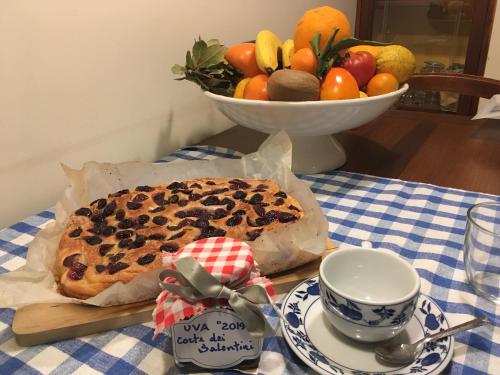 una mesa con un pastel y un bol de fruta en Corte dei Salentini, en Carpignano Salentino