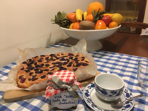uma mesa com um bolo e uma taça de fruta em Corte dei Salentini em Carpignano Salentino