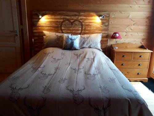 ル・デヴォリュイにあるChalet TERRA LOUPのベッドルーム1室(木製ヘッドボード付きのベッド1台付)