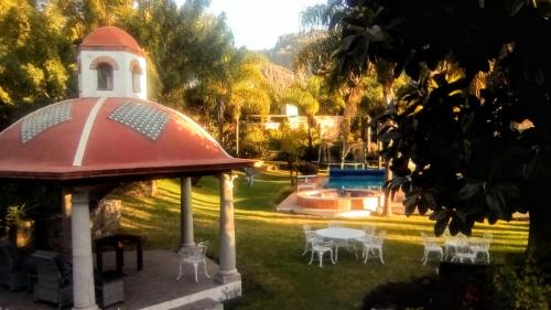 cenador con mesa y sillas en un patio en Hotel Quinta del Sol, en Tepoztlán