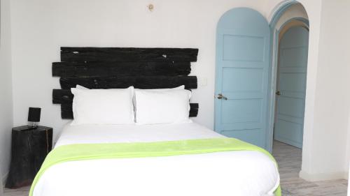 a bedroom with a large white bed and a blue door at Casa Hotel Santa Helena Boutique in Villa de Leyva