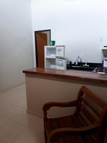 a bar with a counter with a microwave and a chair at Loft Pireneus 2 in Pirenópolis