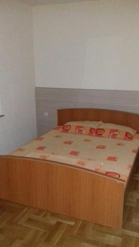 a bed with a wooden frame in a bedroom at Villa Vasojevka in Bar, Susanj