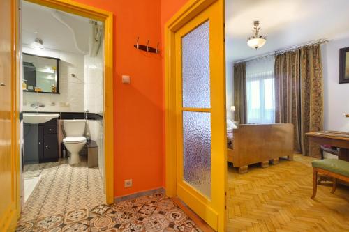 ワルシャワにあるMieszkanko na Konstytucjiのオレンジ色のバスルーム(トイレ、シンク付)