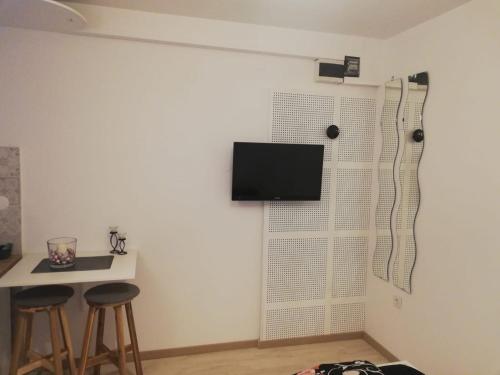 a room with two stools and a television on a wall at Studio Apartment New Home in Zagreb