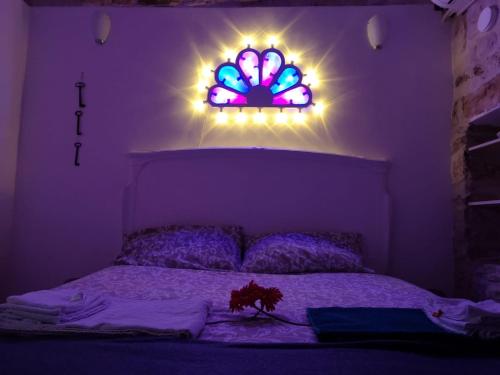 a purple bedroom with a bed with a stained glass window at La Torretta di Gigi - soggiorno in torre medievale in Bisceglie