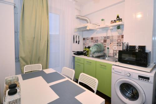 eine Küche mit einem Tisch und einer Waschmaschine in der Unterkunft Stay Inn Apartments in Bukarest