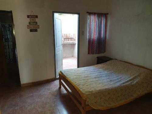 Departamentos ramallo في رامالو: غرفة نوم بسرير وباب للنوافذ
