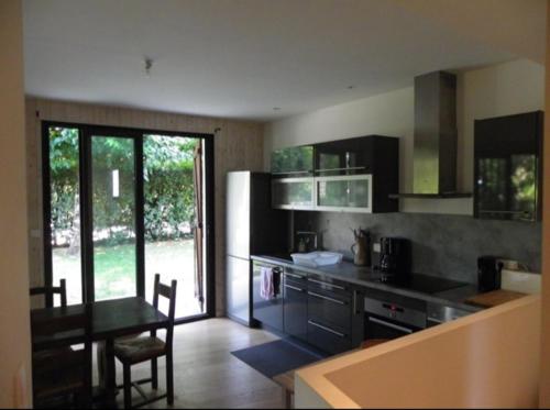 eine Küche mit einer Theke und einem Tisch darin in der Unterkunft Appartement cosy village de L'Herbe in Lège-Cap-Ferret