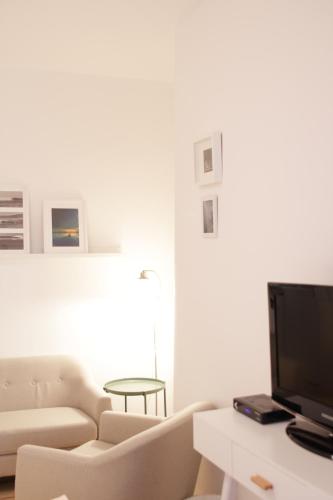 a white living room with a couch and a tv at Über den Dächern Boppards in Boppard