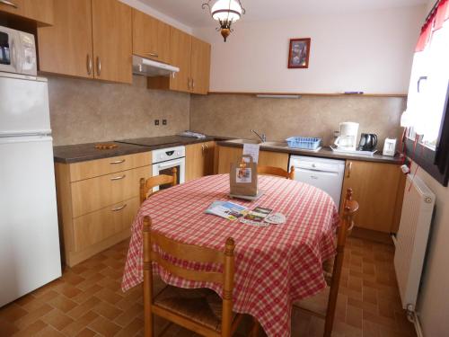 a kitchen with a table with a red and white table cloth at Chalet les Ombrettes in Ceillac