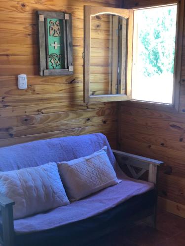 a blue couch in a room with wooden walls at Terrazas de Uspallata in Uspallata