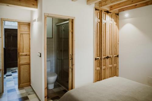 a bedroom with a bed and a bathroom with a toilet at Casa Rural el Cocodrilo in Agés